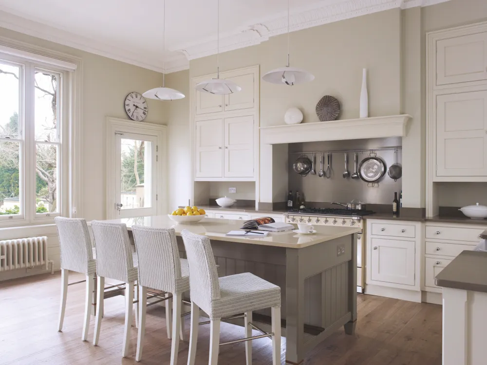 Kitchen from The English collection at Martin Moore with main furniture painted in ‘Stone II’ and the island in ‘Stone III’ from Paint & Paper Library. Worktops are in Caesarstone ‘Ginger’ and Compac ‘Botticino’. Martin Moore kitchens start from £35,000