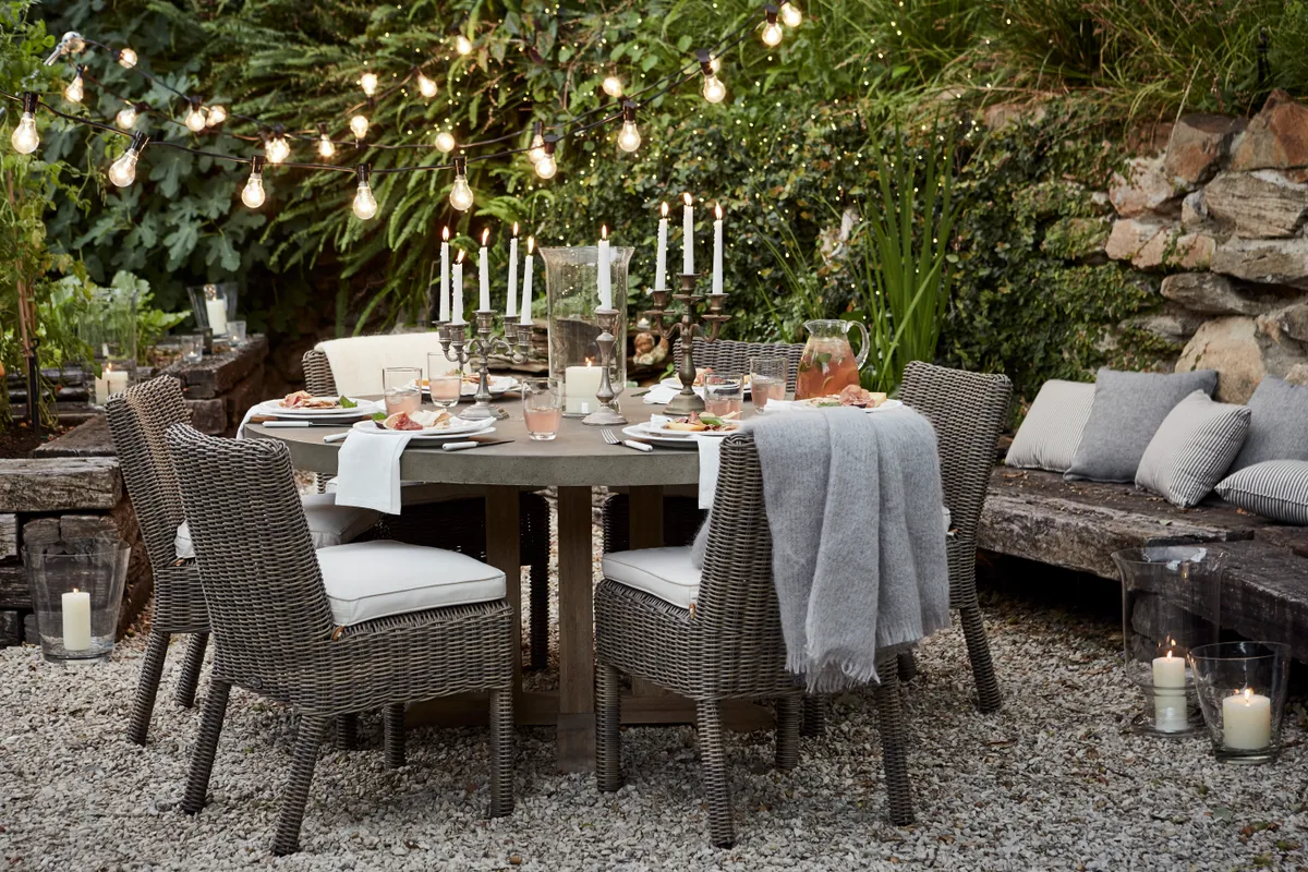 A gravel patio area with wicker chairs and table