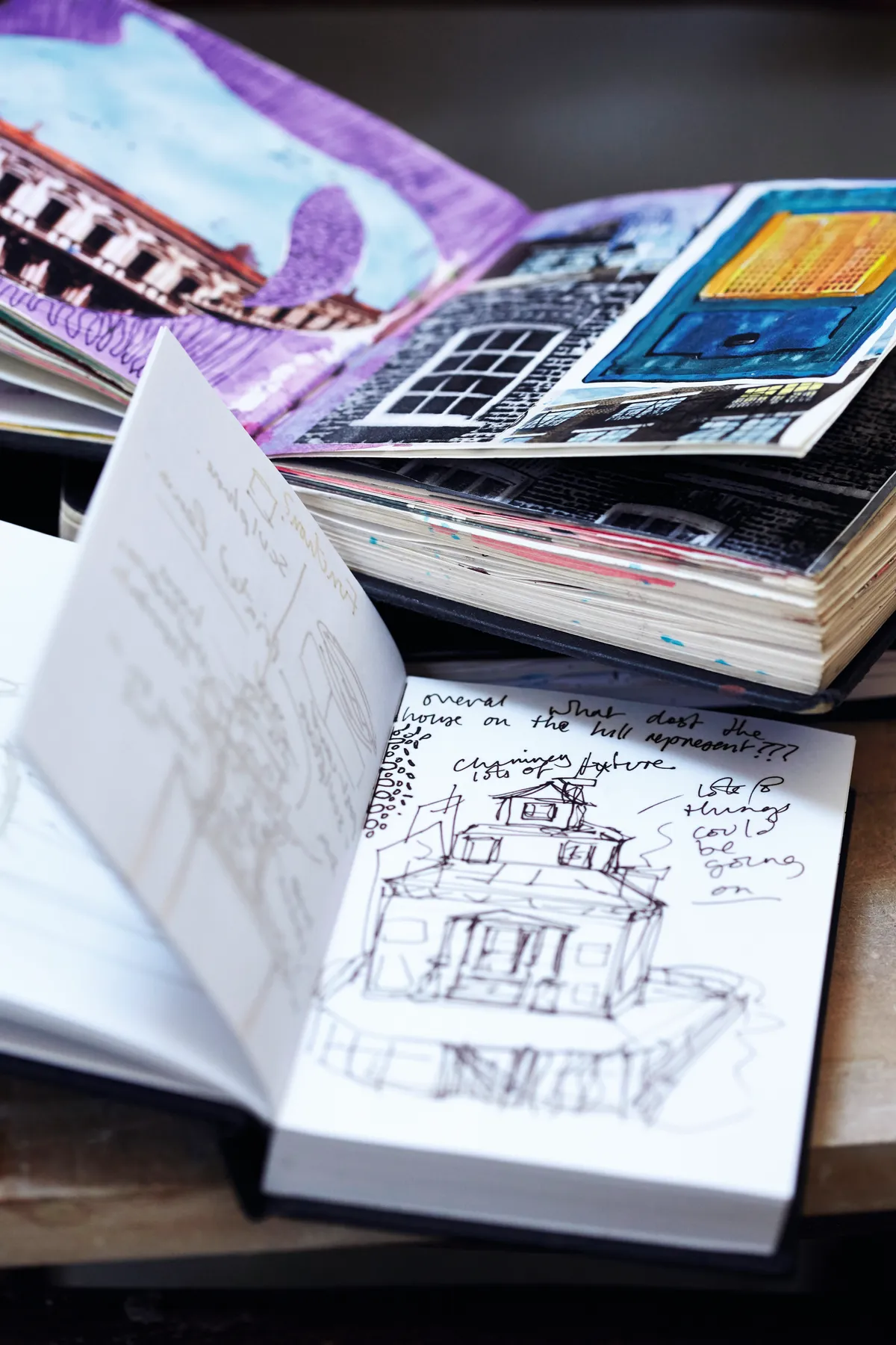 Open notebooks filled with sketches in Alice Mara's studio