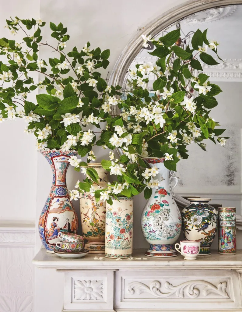 Japanese ceramic vases filled with tall white flowers and green foliage