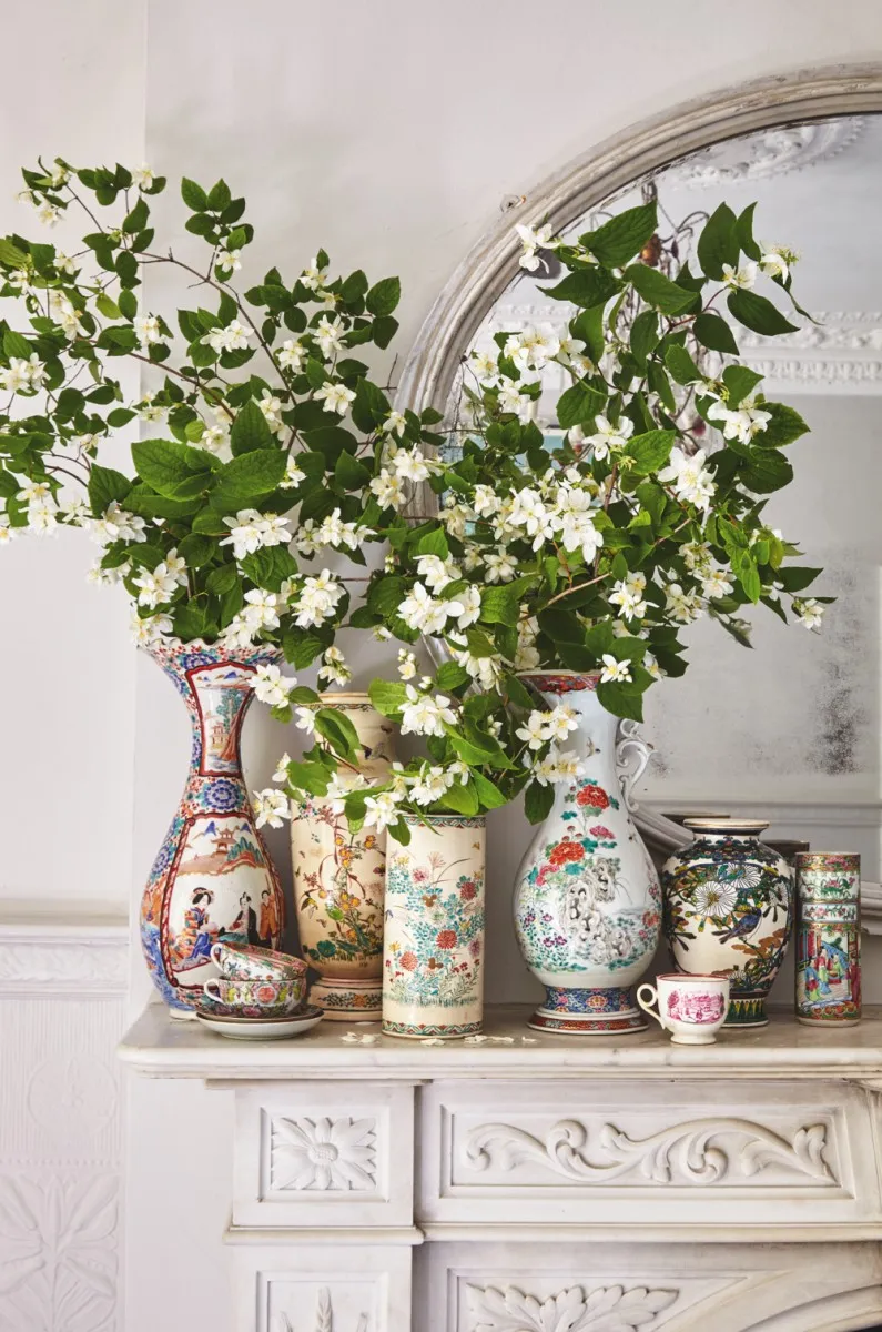 Japanese ceramic vases filled with tall white flowers and green foliage