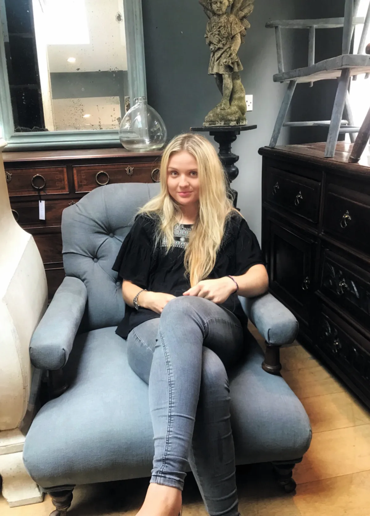 Antiques dealer Lily Johnston sat on a reupholstered Victorian armchair in her showroom