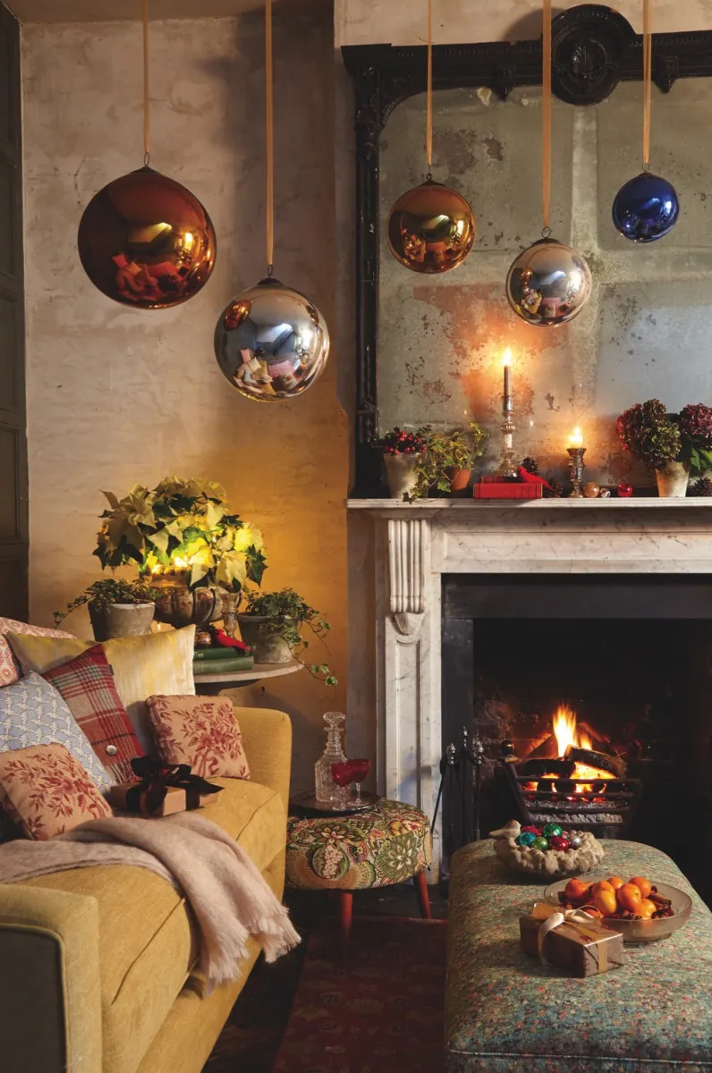 A selection of antique witch balls hung above a fireplace