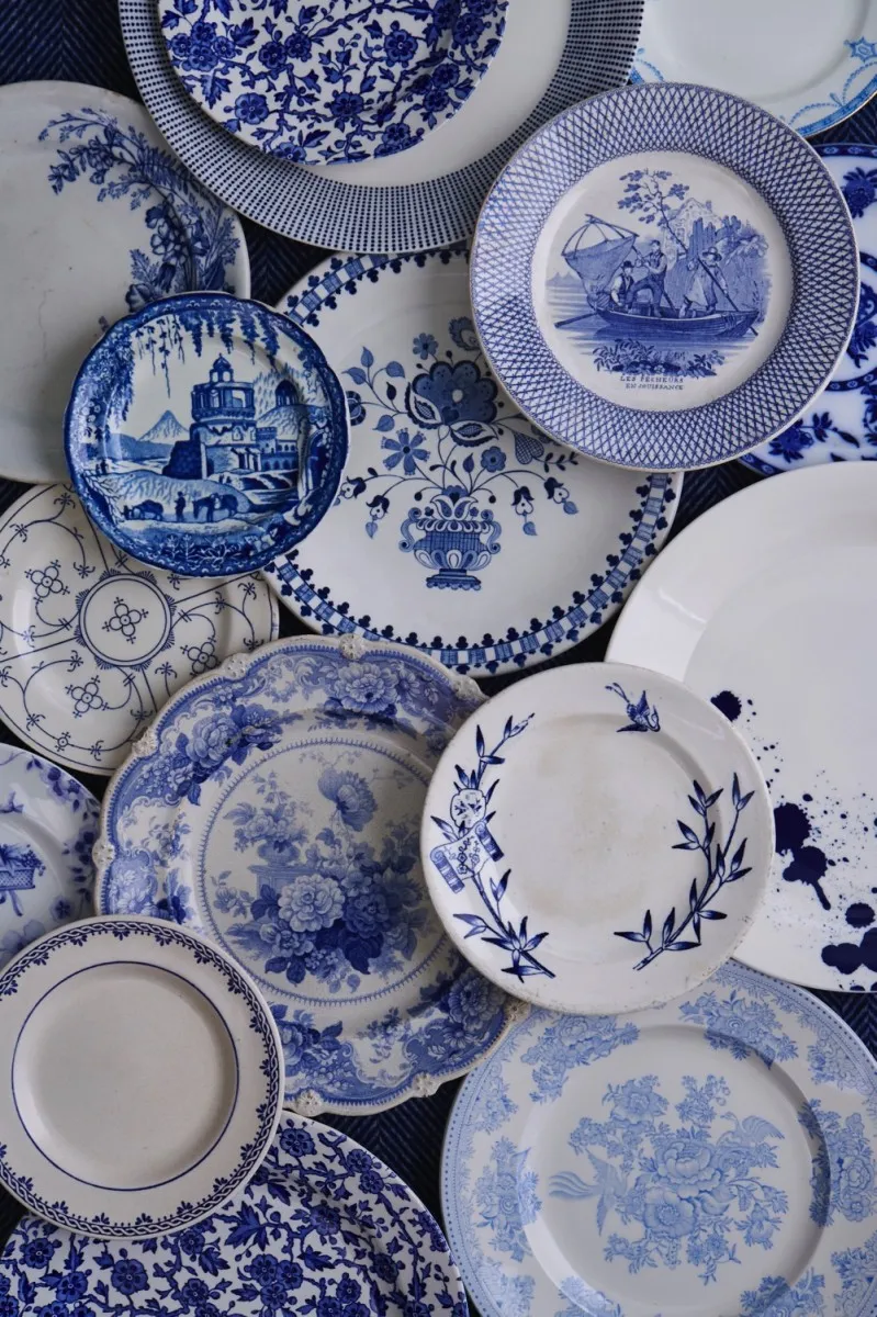 A collection of vintage and modern blue and white plates spread out on the floor