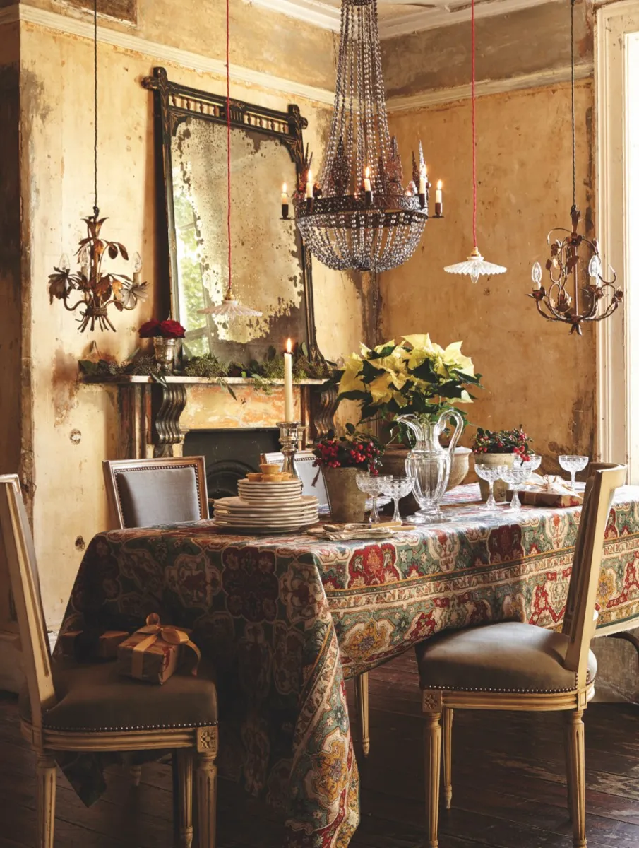 A chandelier hangs above a festive themed dining table