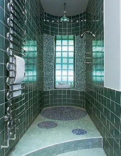 A shower room with green tiles on the wall