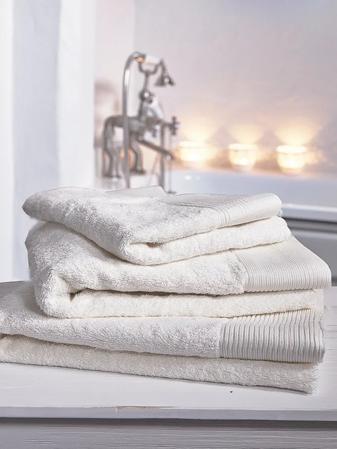 Soft white towels in a candle-lit bathroom