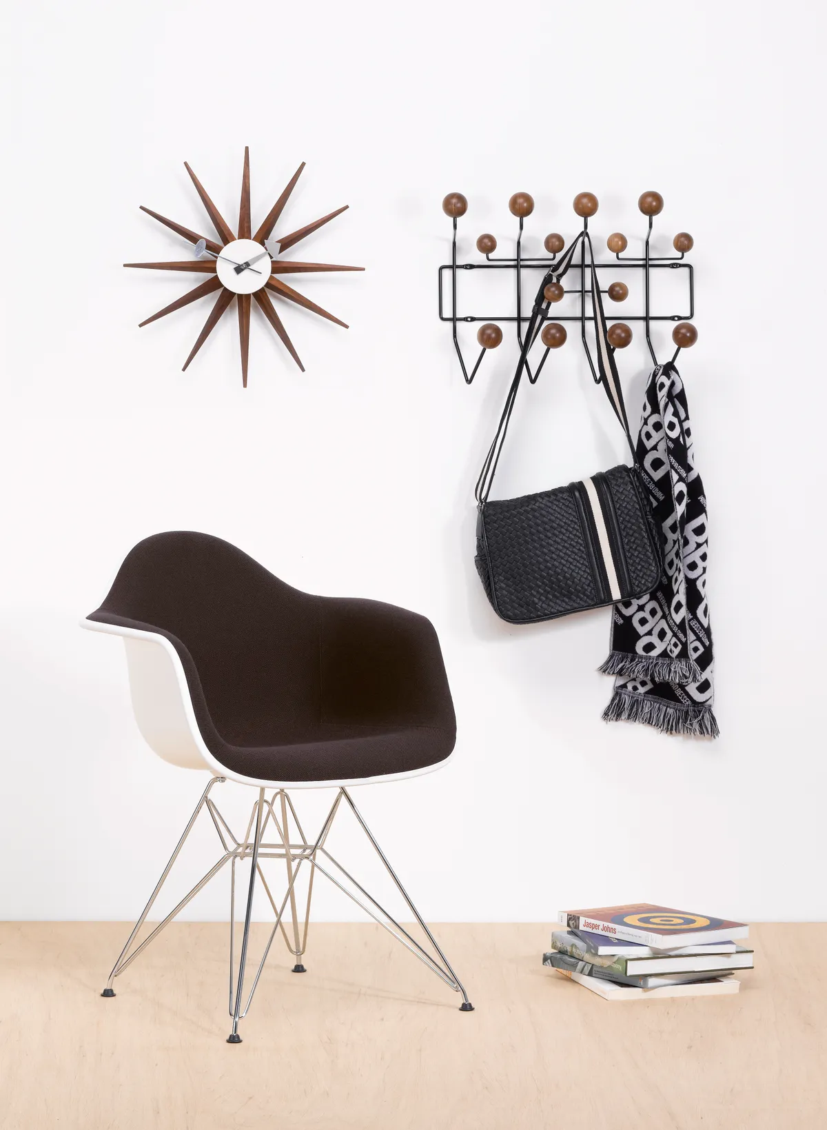 A special edition Eames Hang it All beside an Eames DSW armchair and a mid-century clock