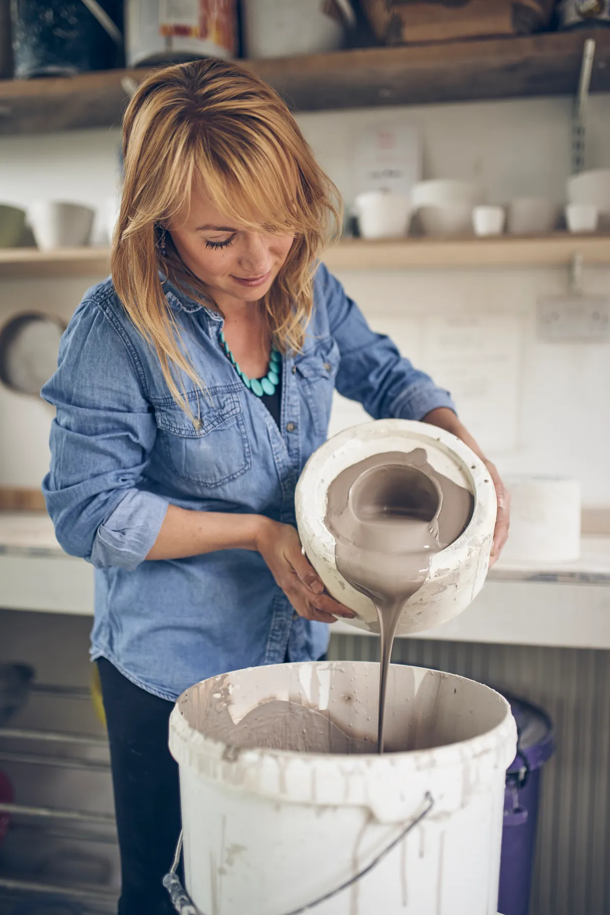 Helena Haran pours slip into a mould to create a ceramic planter