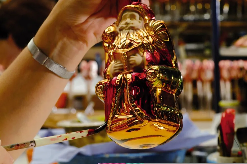 A Santa glass bauble being painted