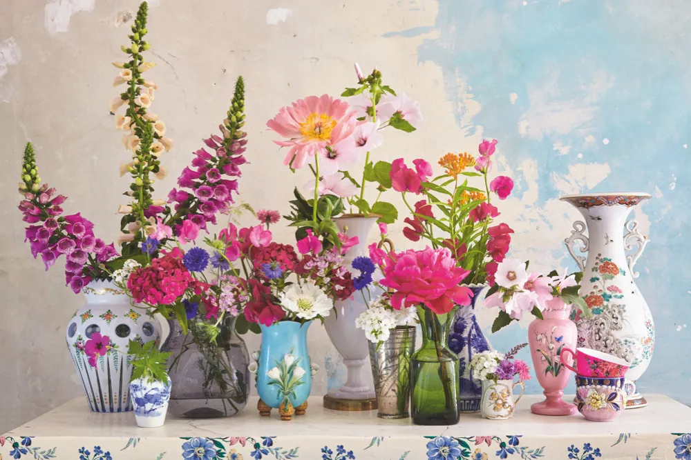 An array of antique glass vases filled with summer flowers