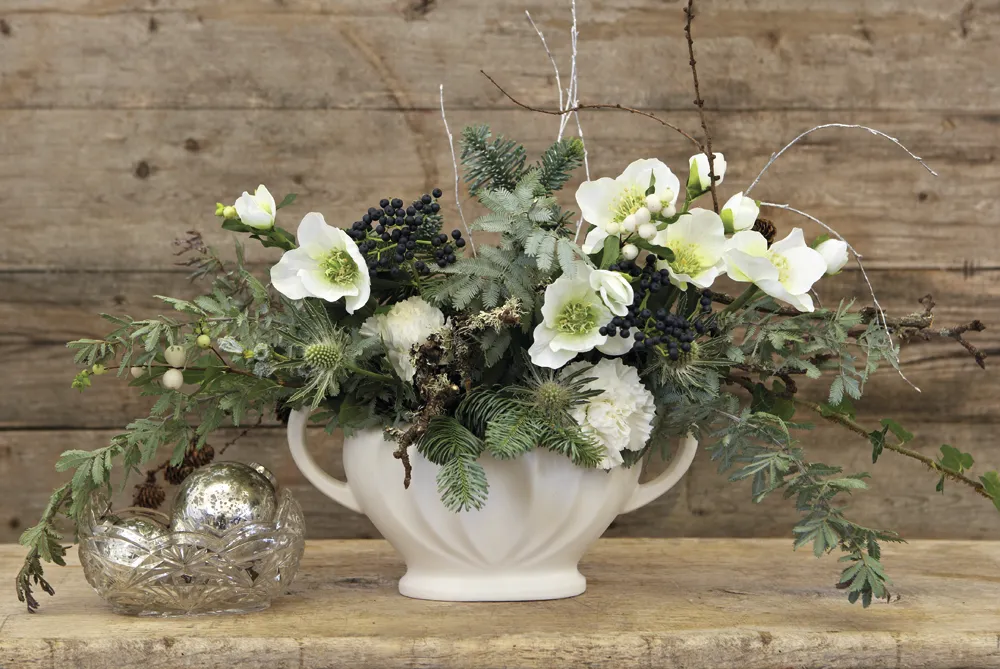 A Constance Spry vase filled with festive blooms and greenery