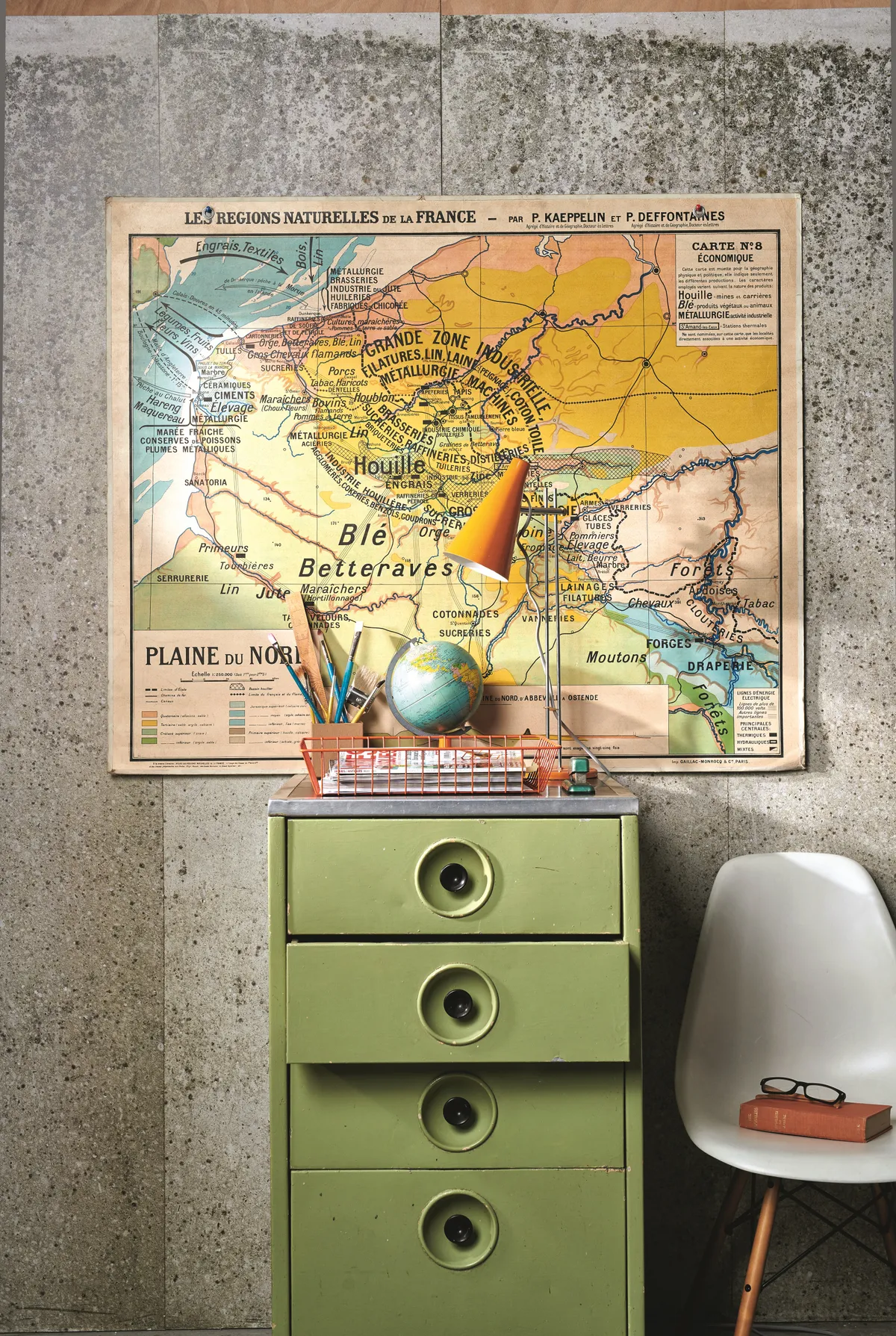 A vintage orange wire tray atop a green metal filing cabinet.