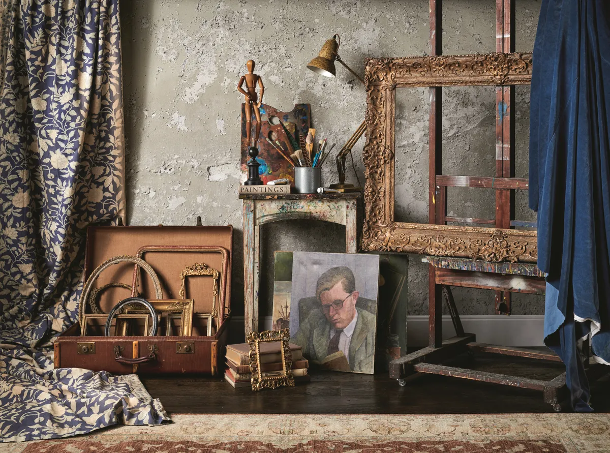 An array of antique gilded frames, paintings and easels against an exposed concrete wall