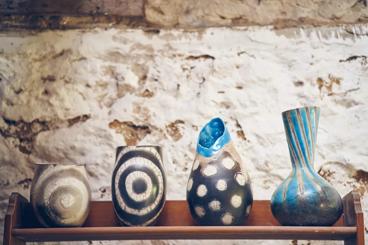 An array of Catherine Lucktaylor's ceramic vases arranged on a shelf in her workshop