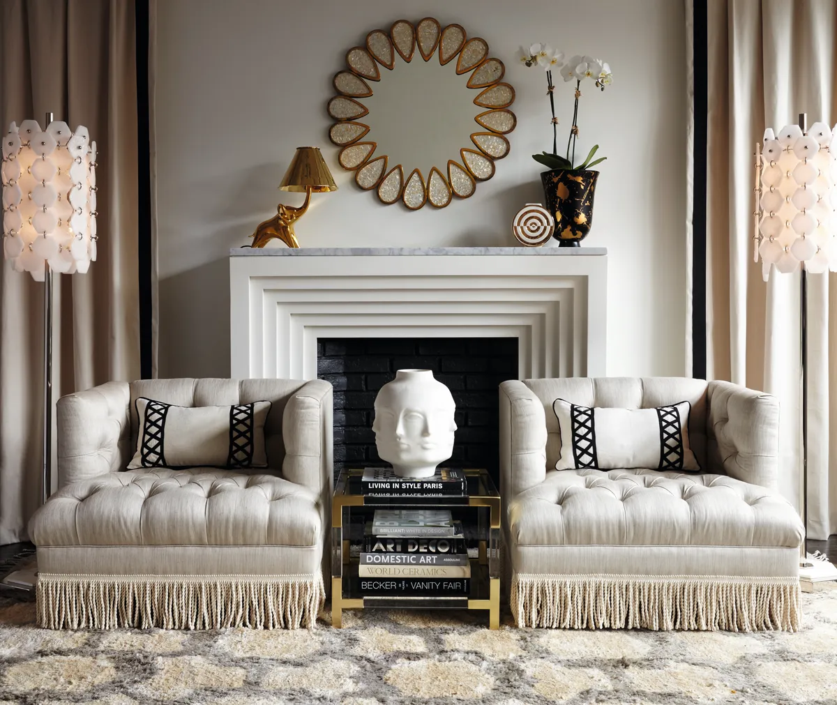Two fringed armchairs flank an Art Deco fireplace