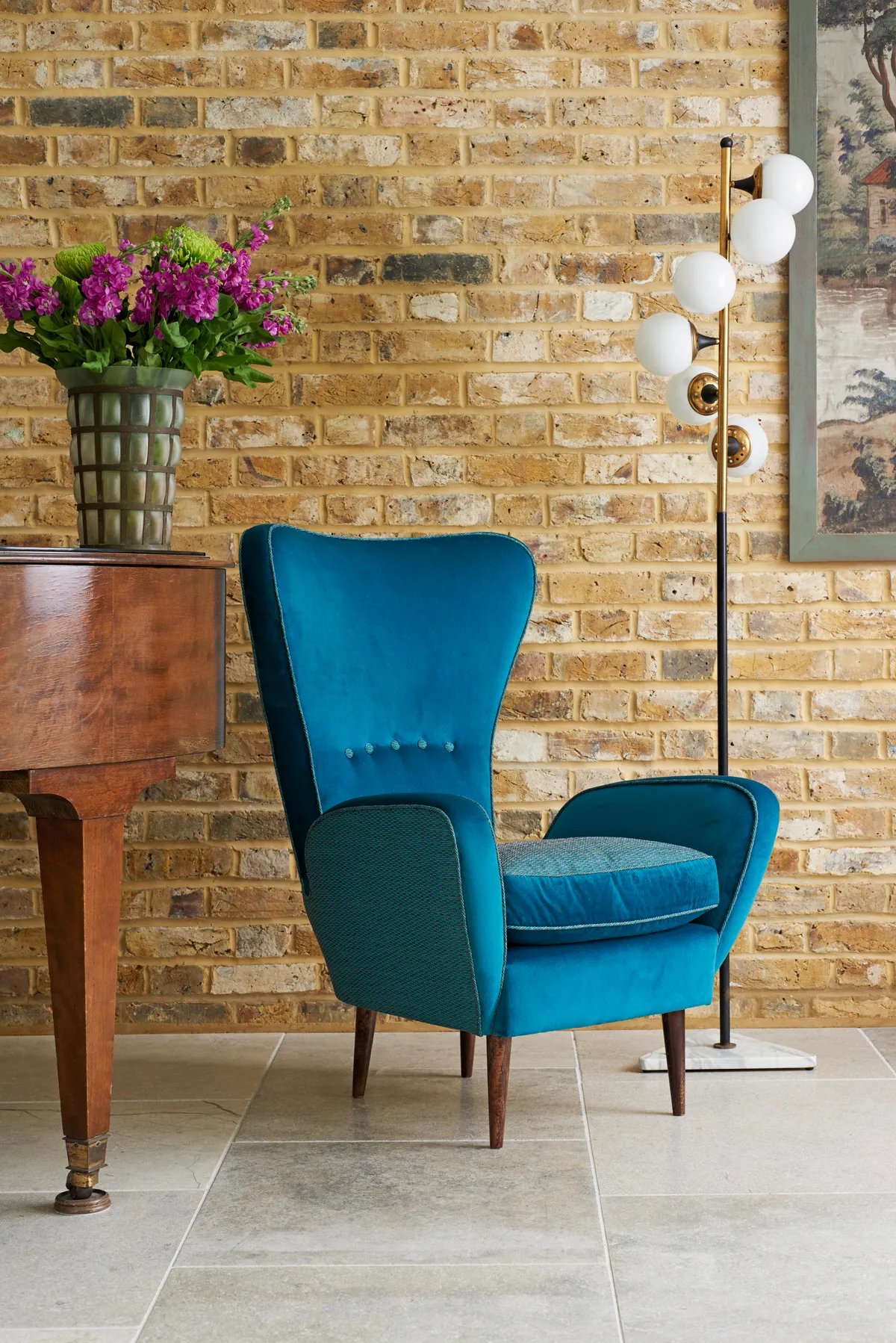 A mid-century style armchair upholstered in rich, dark blue velvet