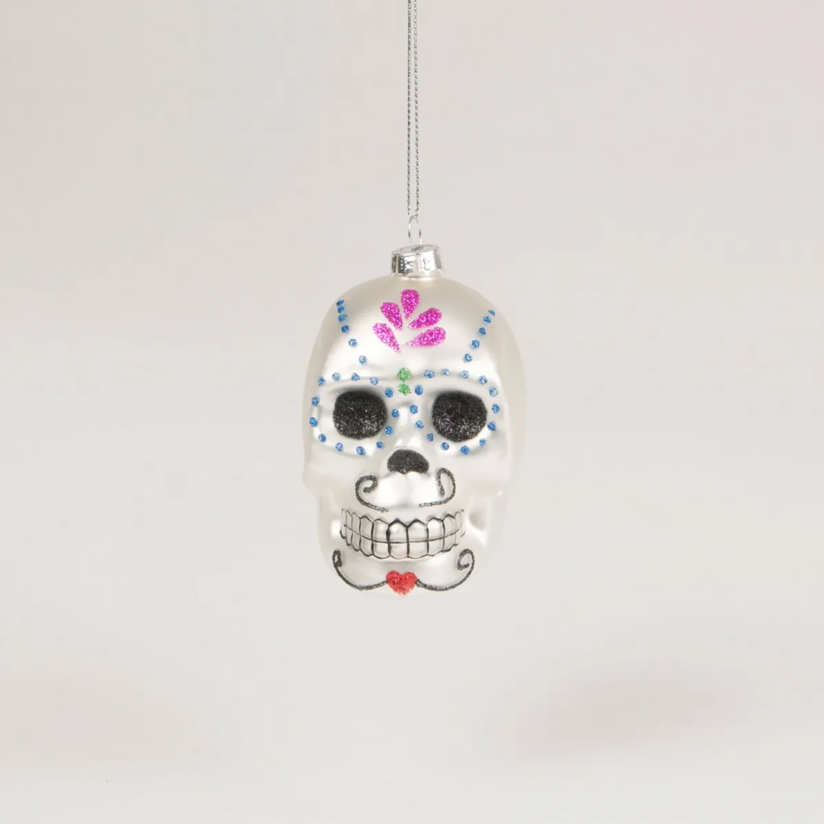 A glittery bauble shaped like a traditional Day of the Dead sugar skull.