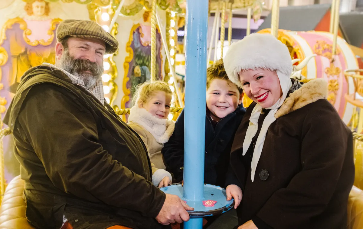 Dick and Angel Strawbridge, plus their children, dressed for winter on an old-fashioned fairground ride