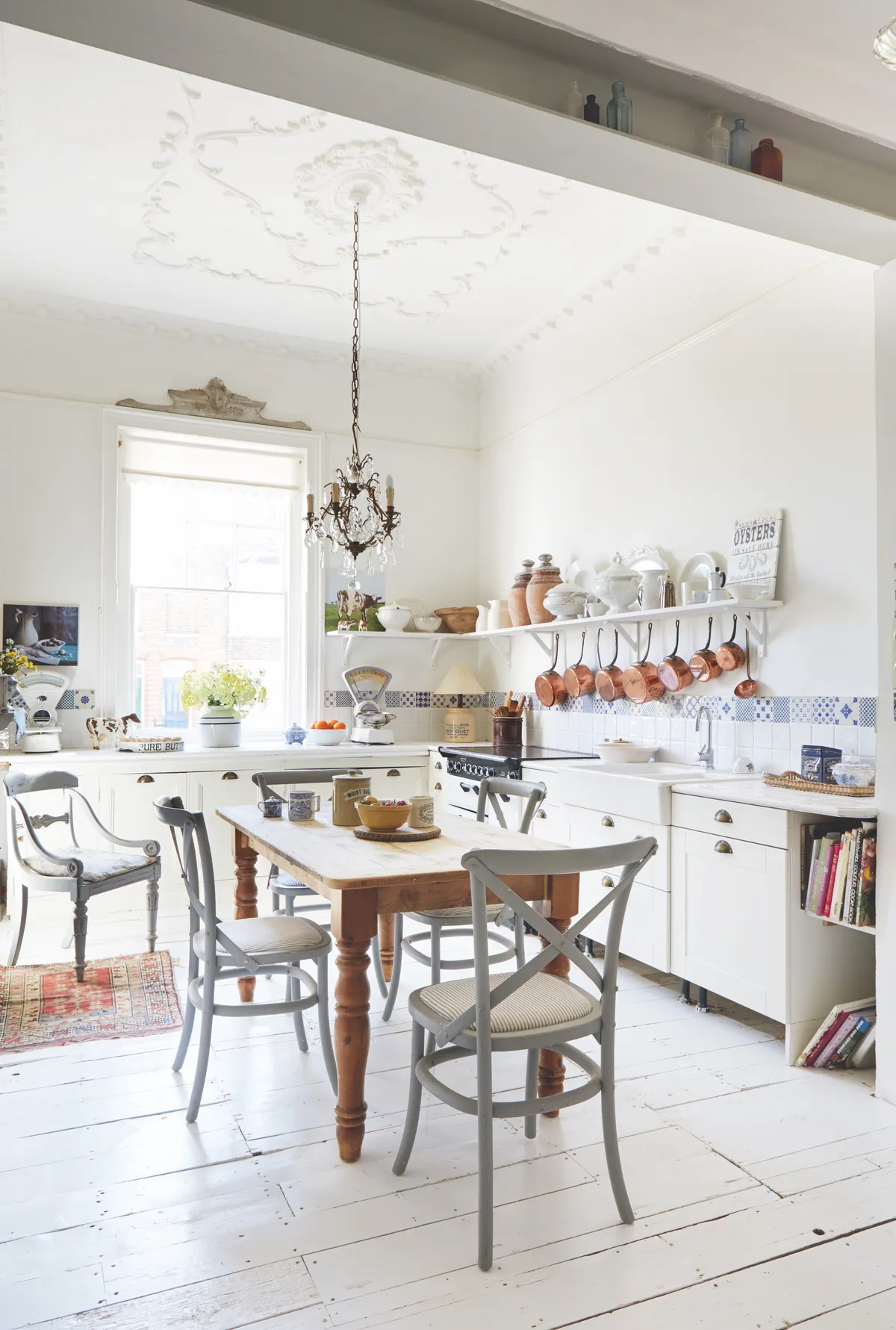 A light and bright country kitchen with antique copper pans and vintage ceramics