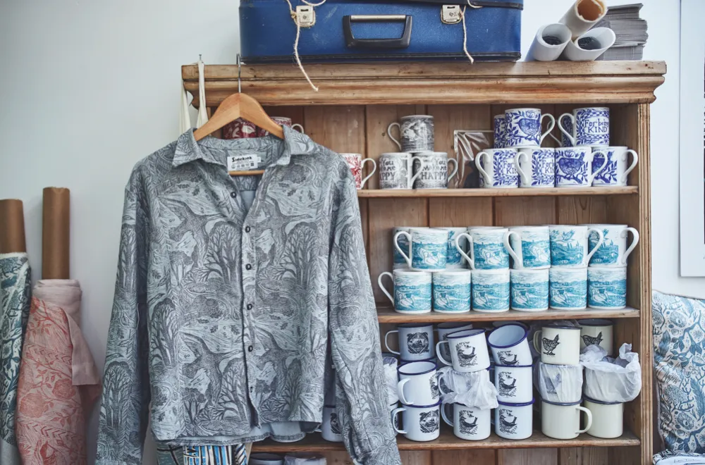 Several of Lou's designs printed on clothes, mugs and tea towels