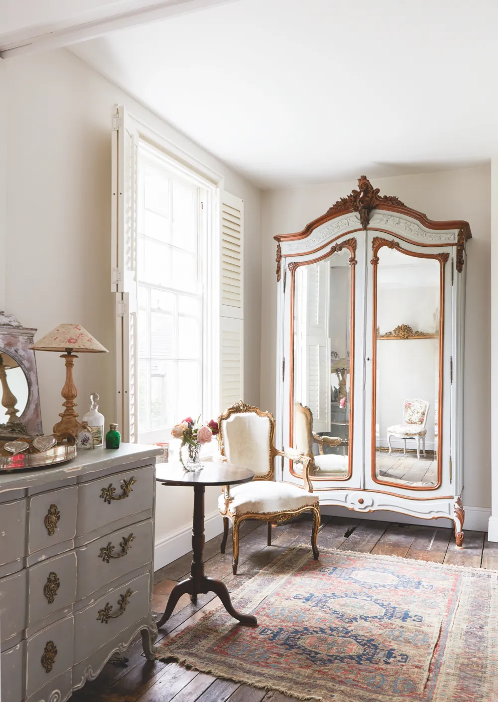 A delicate gilt chair is a perfect partner to this charming French armoire.