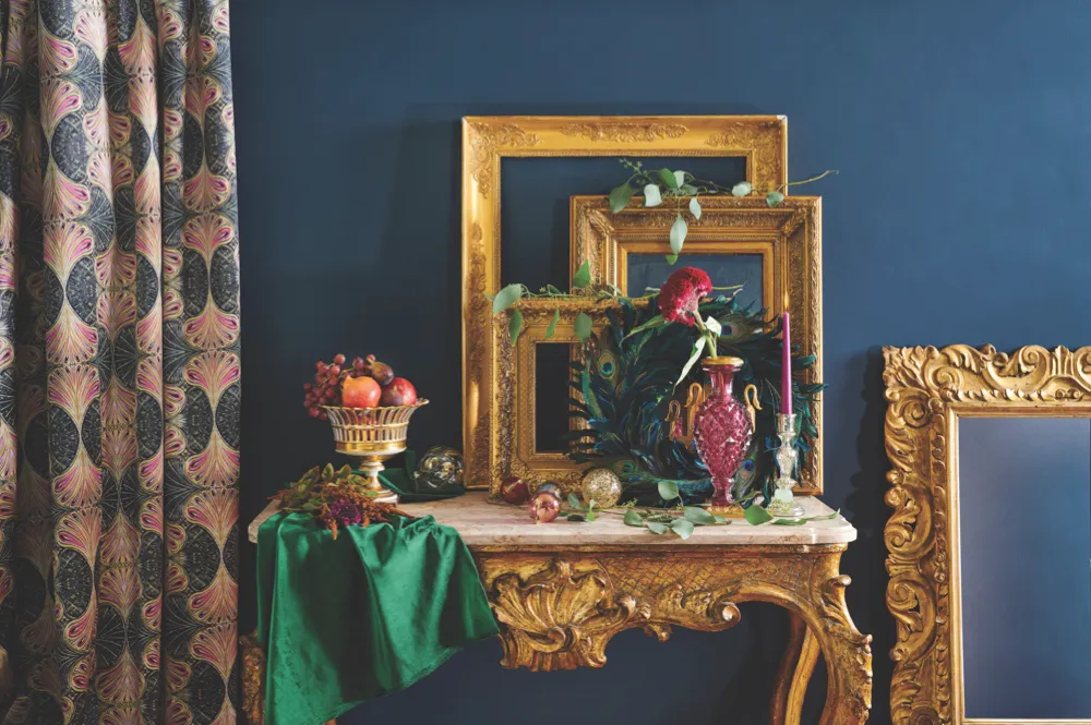 Hall table dressed with fresh foliage and ornate gilt frames