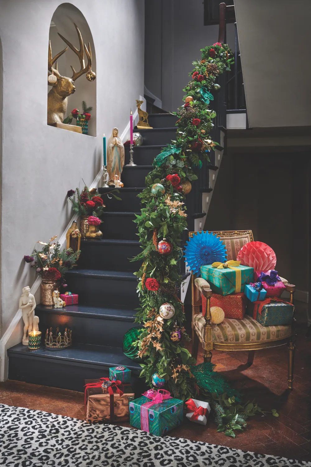 Staircase decorated with swags of greenery and oversized baubles