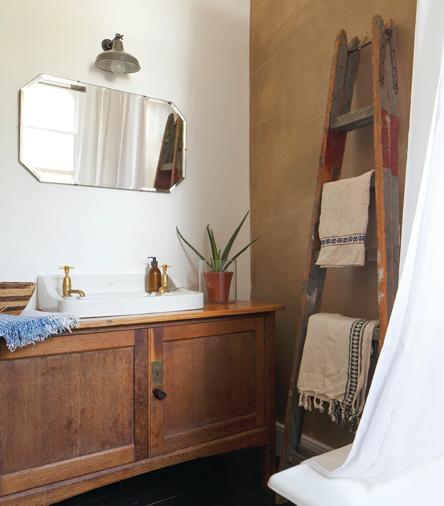 A vintage wooden ladder makes a beautiful towel rail in a bathroom