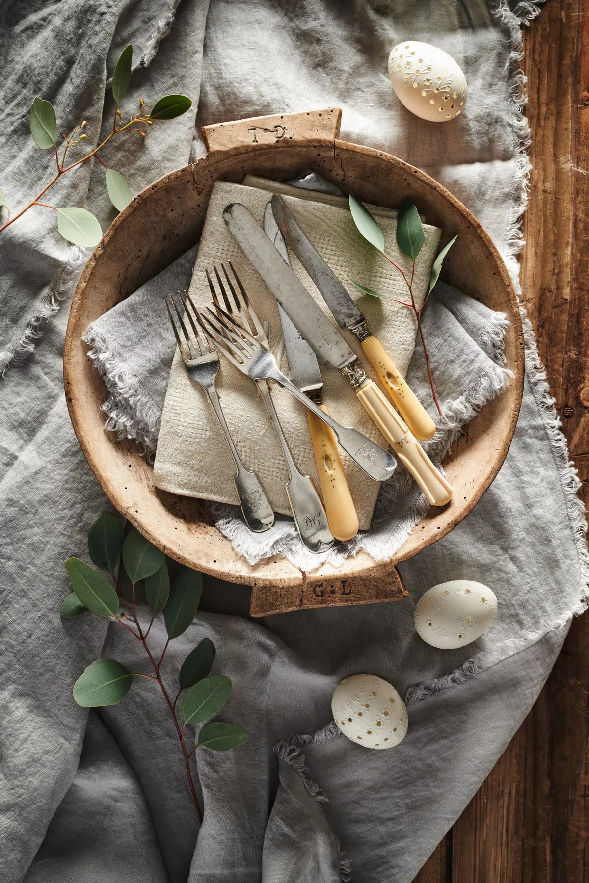 The natural textures of wood and linen are a happy pairing. Choose monogrammed cutlery and sprigs of foliage for a pleasing lunch table. For an Easter hit, add eggs, either daintily decorated or plain.