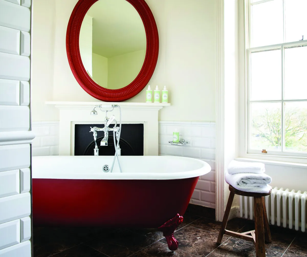 A stylish red bathtub in one of the Family rooms.