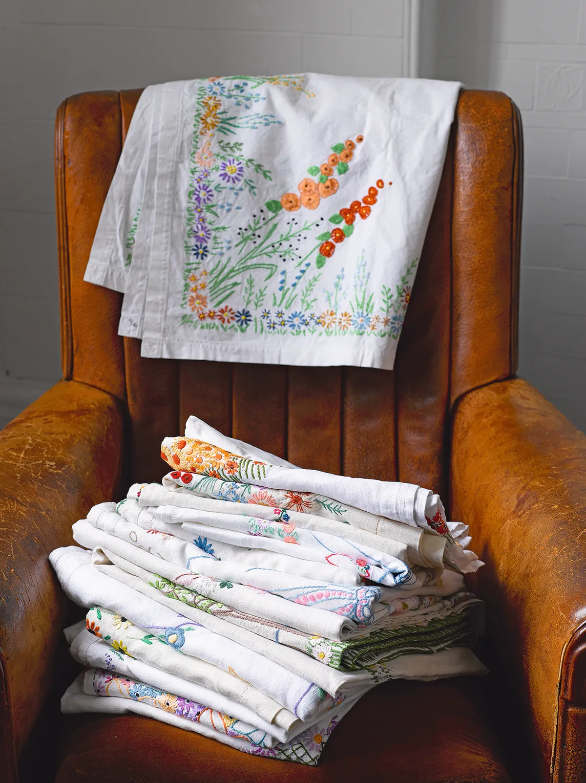 Embroidered tablecloths on an antique armchair.