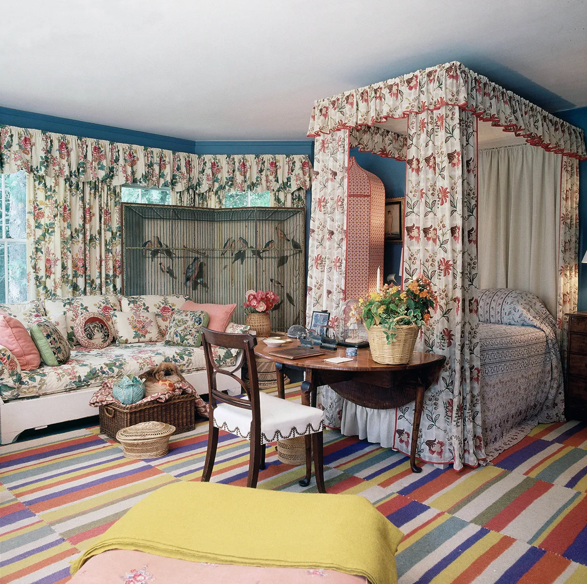 Chintz is teamed with a bold striped carpet in Sister Parish’s 1970s Maine home
