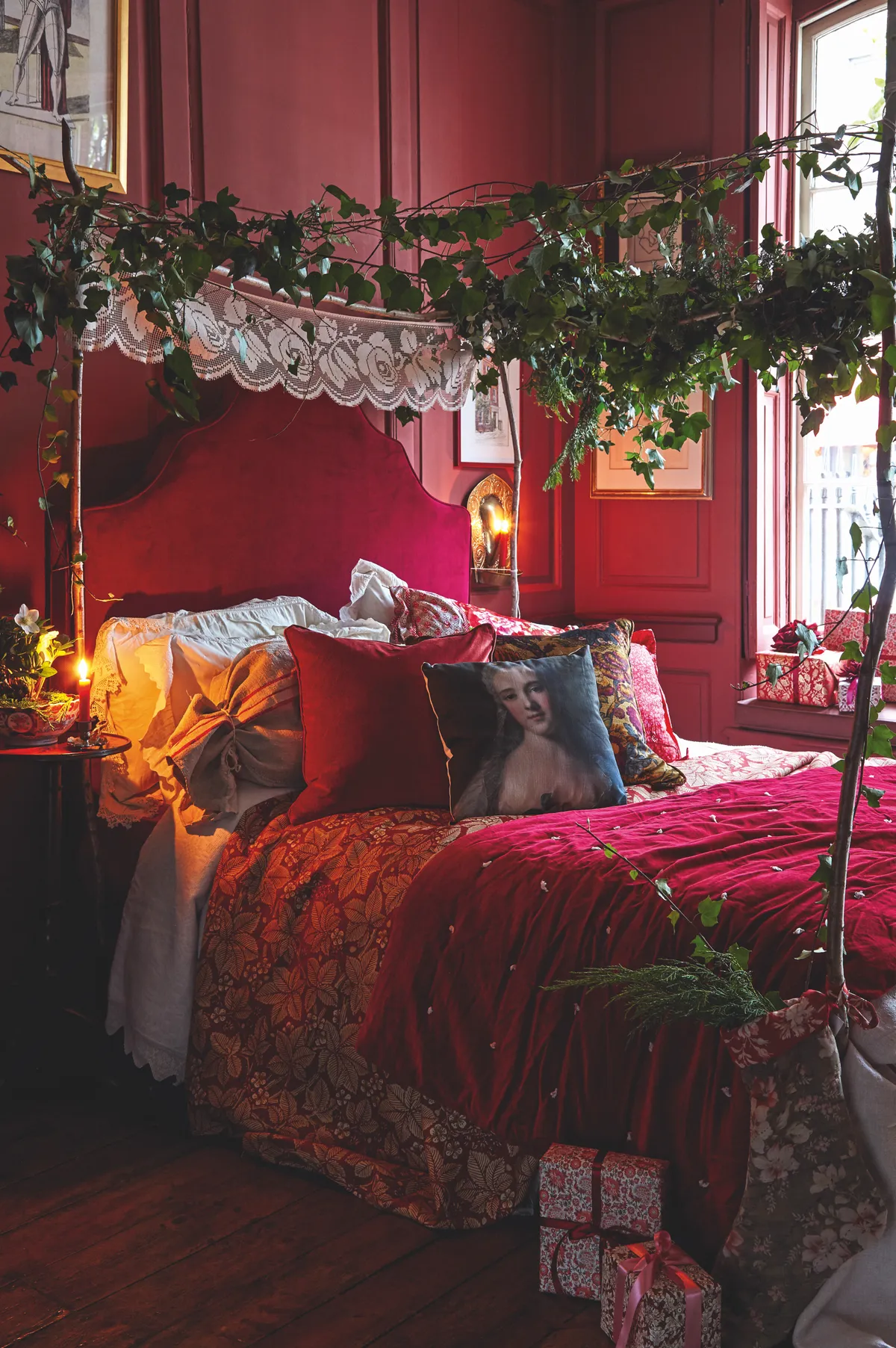 Layer your spare bed with linen, throws and cushions in shades of crimson, white and gold. Antique lace, velvet and a canopy made from boughs of natural foliage produce a welcoming festive haven for your guests to withdraw to