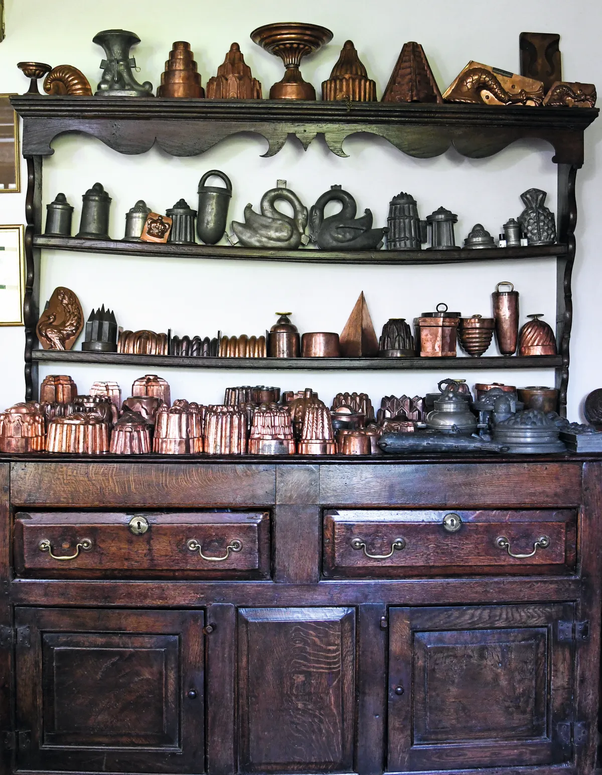 A vast collection of antique copper jelly moulds.