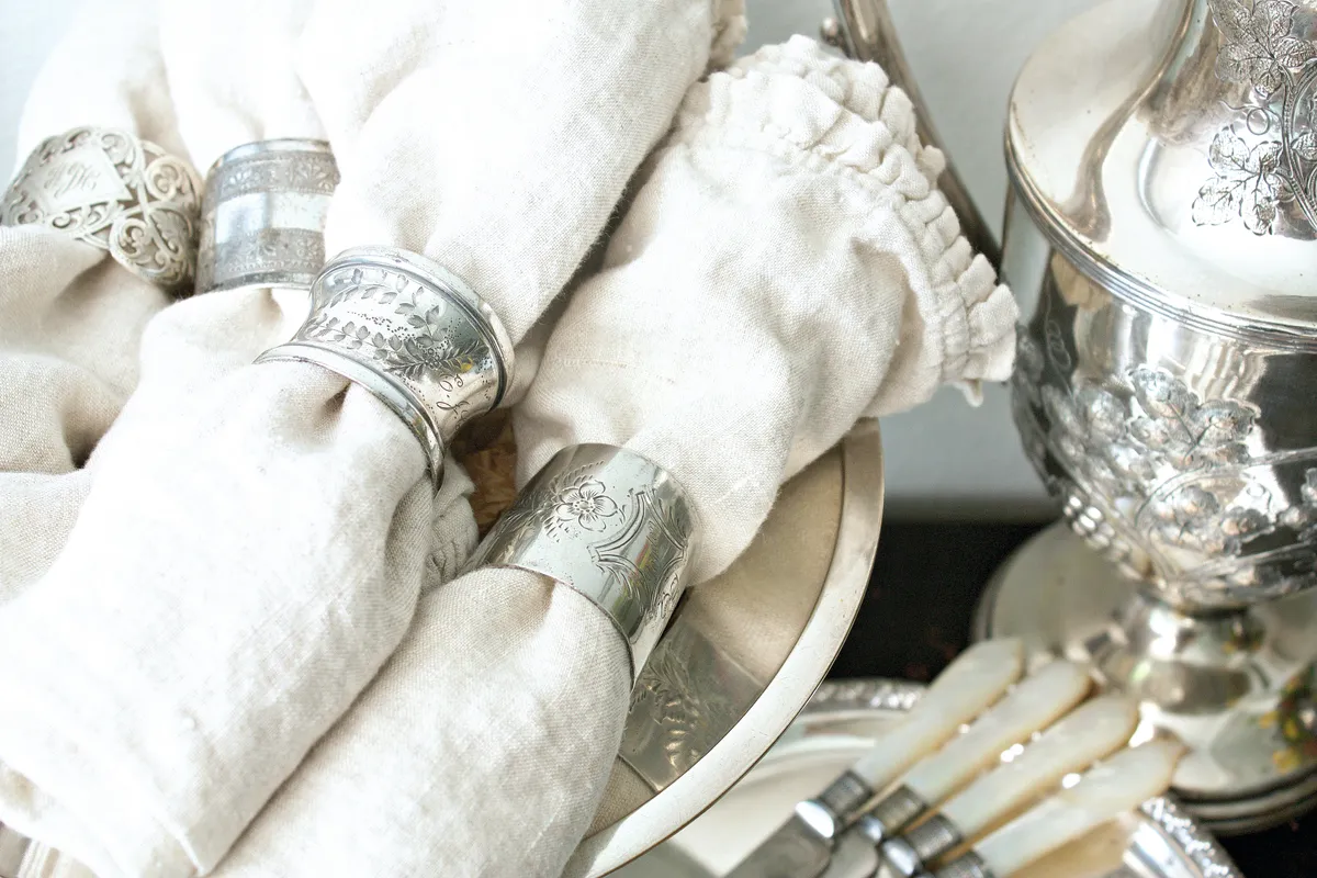 Antique silver napkin rings on white frilly napkins