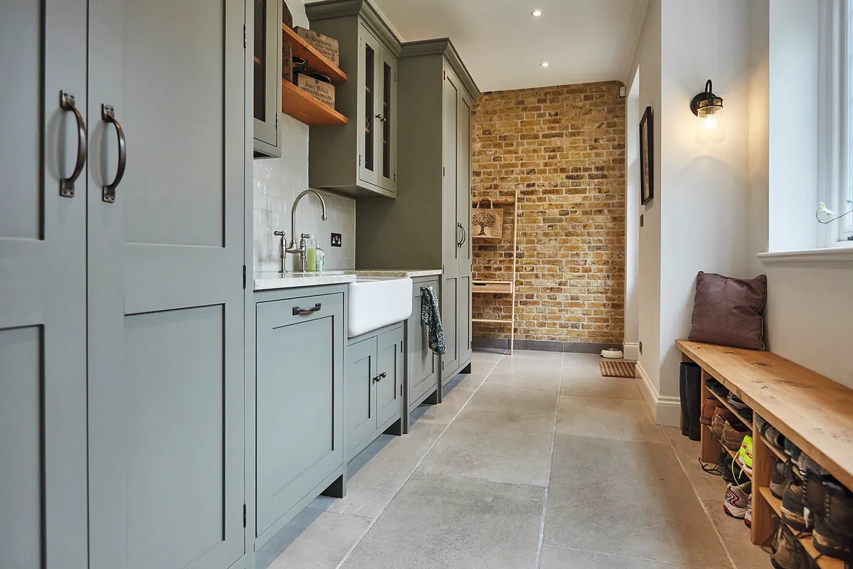 This bespoke utility room by The Main Company features floor-to-ceiling cupboard space, making the most of the storage opportunities and providing ample height for brooms, mops and ironing boards.