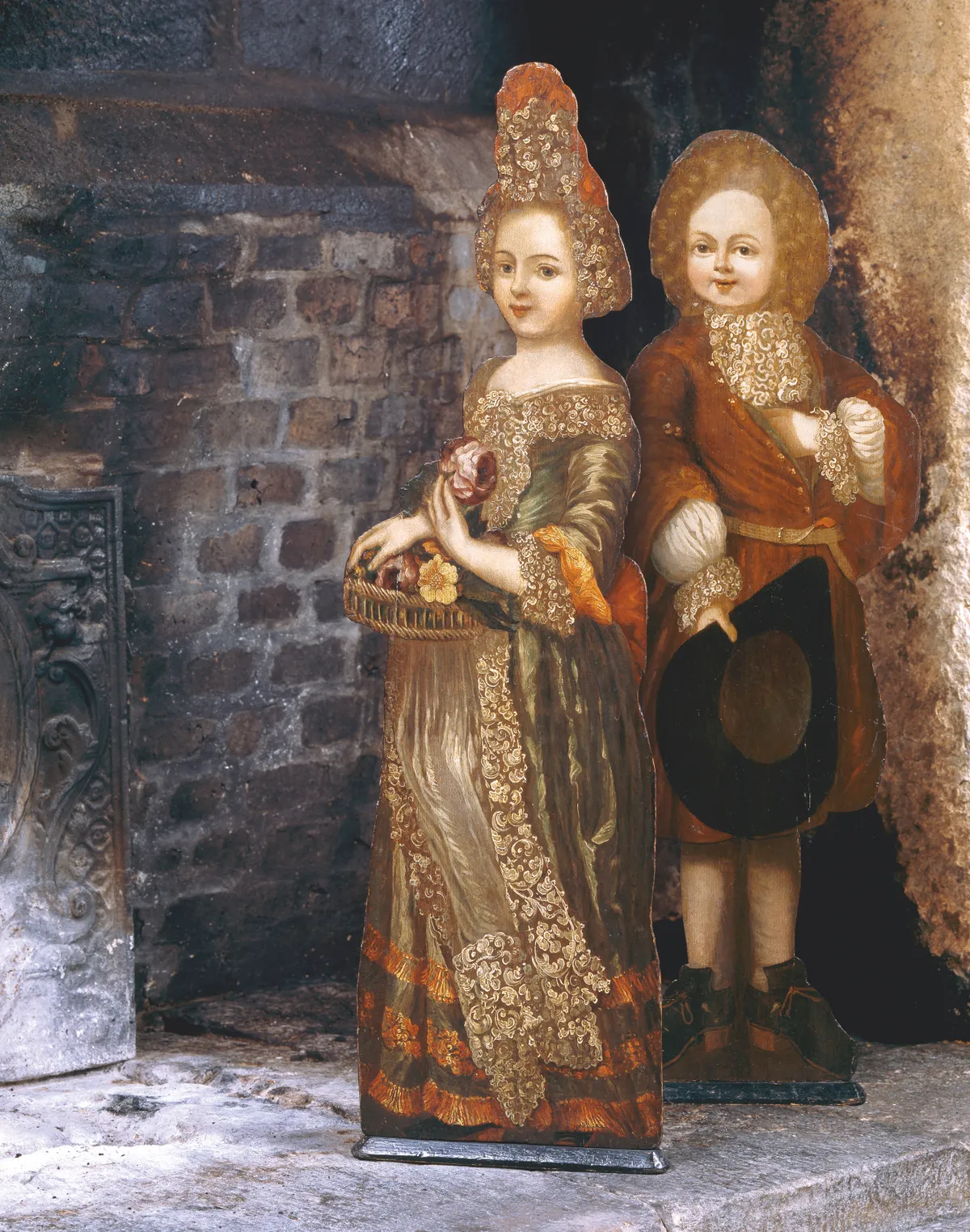 Early 18th-century painted dummy boards from the Great Chamber at the National Trust’s Trerice in Cornwall, depicting a girl holding a basket of flowers and a boy holding a hat. © National Trust Images/John Hammond