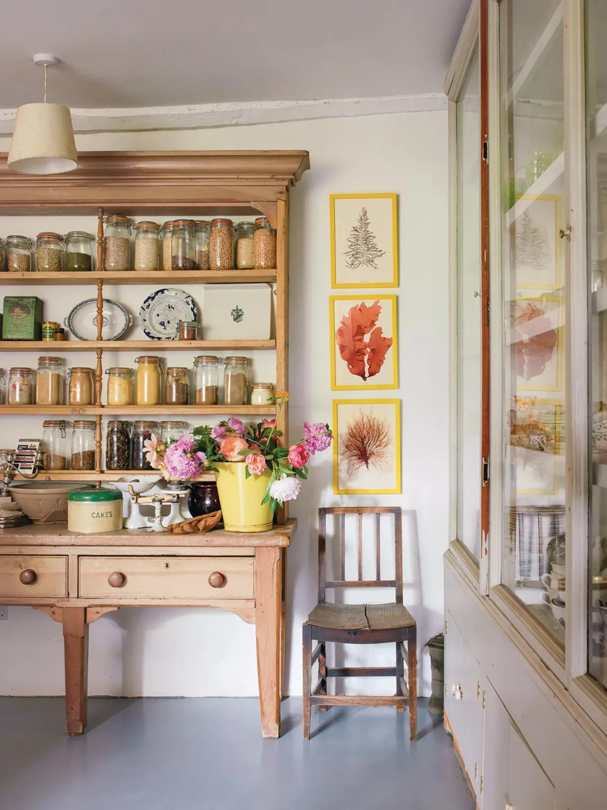Wardington Manor: Dresser in the scullery with prints framed on the wall next to it.