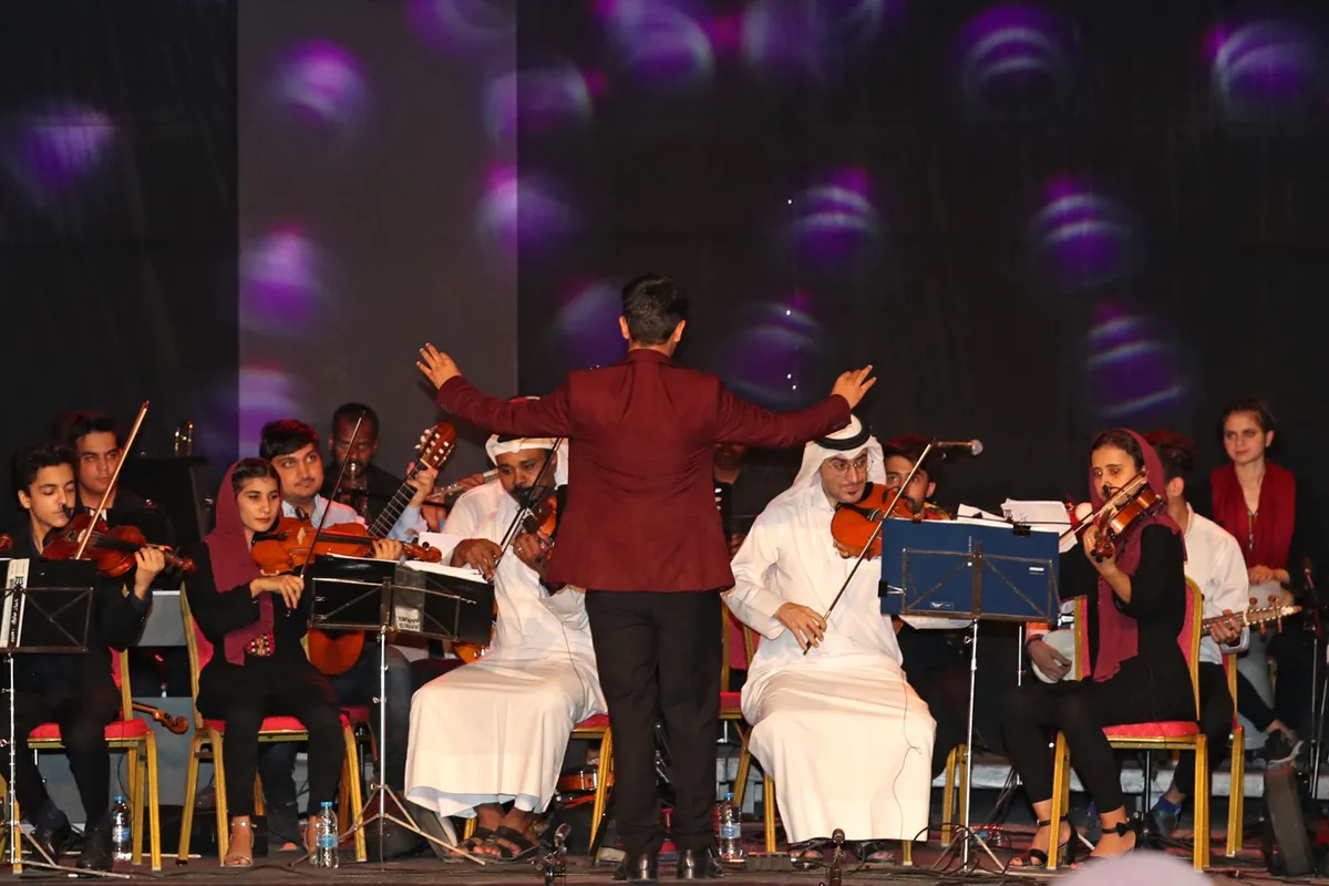 Conductor of the Afghan national orchestra Mohammed Qambar Nawshad leads musicians of the Afghanistan National Institute of music (ANIM) which all-female Zohra orchestra is part of, during a concert in the Qatari capital Doha on October 18, 2021. (Photo by AFP) (Photo by -/AFP via Getty Images)