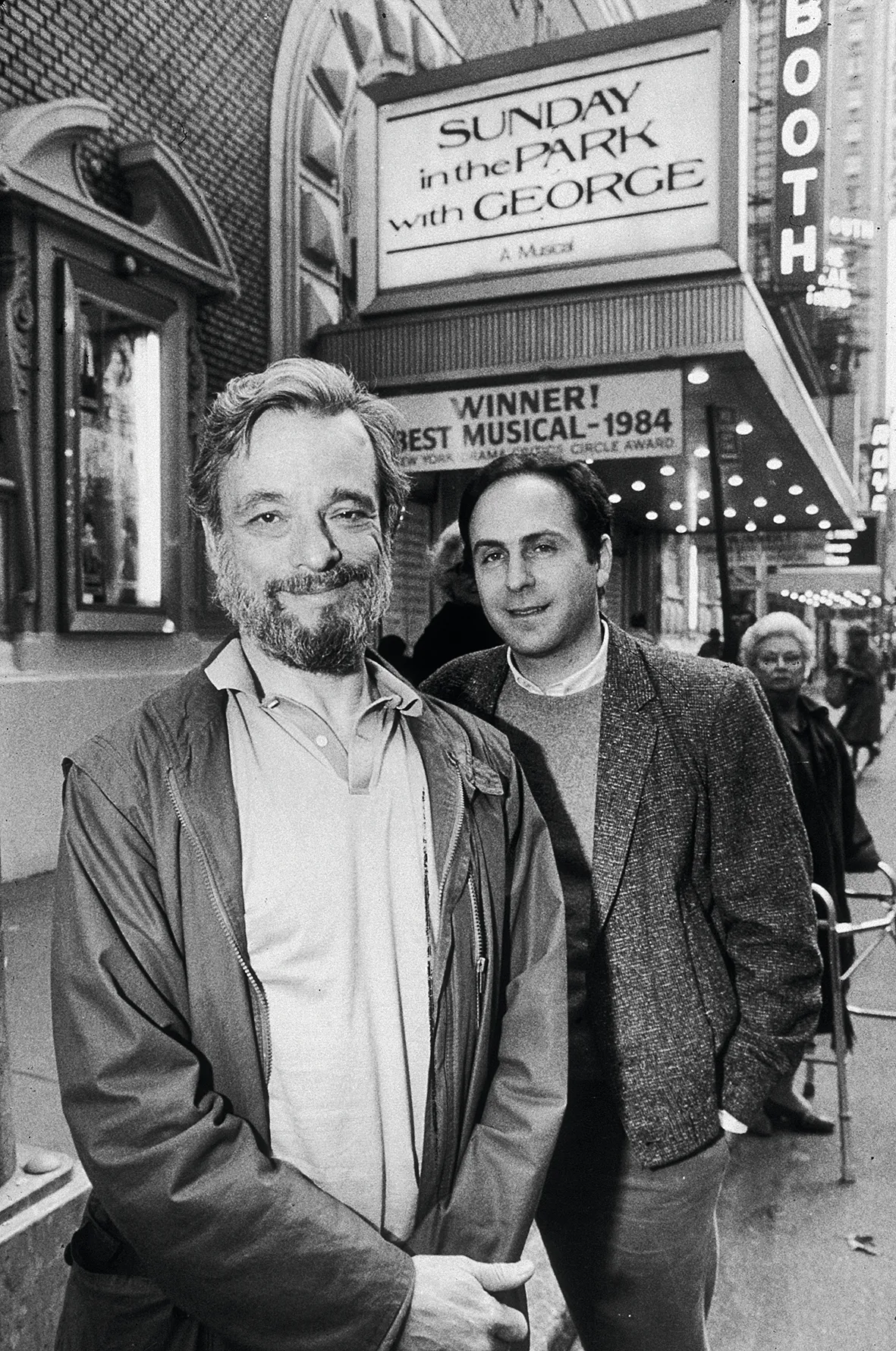 24th April 1985: L-R: American composer Stephen Sondheim and playwright James Lapine pose in front of the marquee of the Booth Theatre on 45th Street, New York City. They won the Pulitzer Prize and the Tony Award for their musical, 'Sunday In The Park With George,' playing at the theatre. (Photo by Sara Krulwich/New York Times Co./Getty Images)