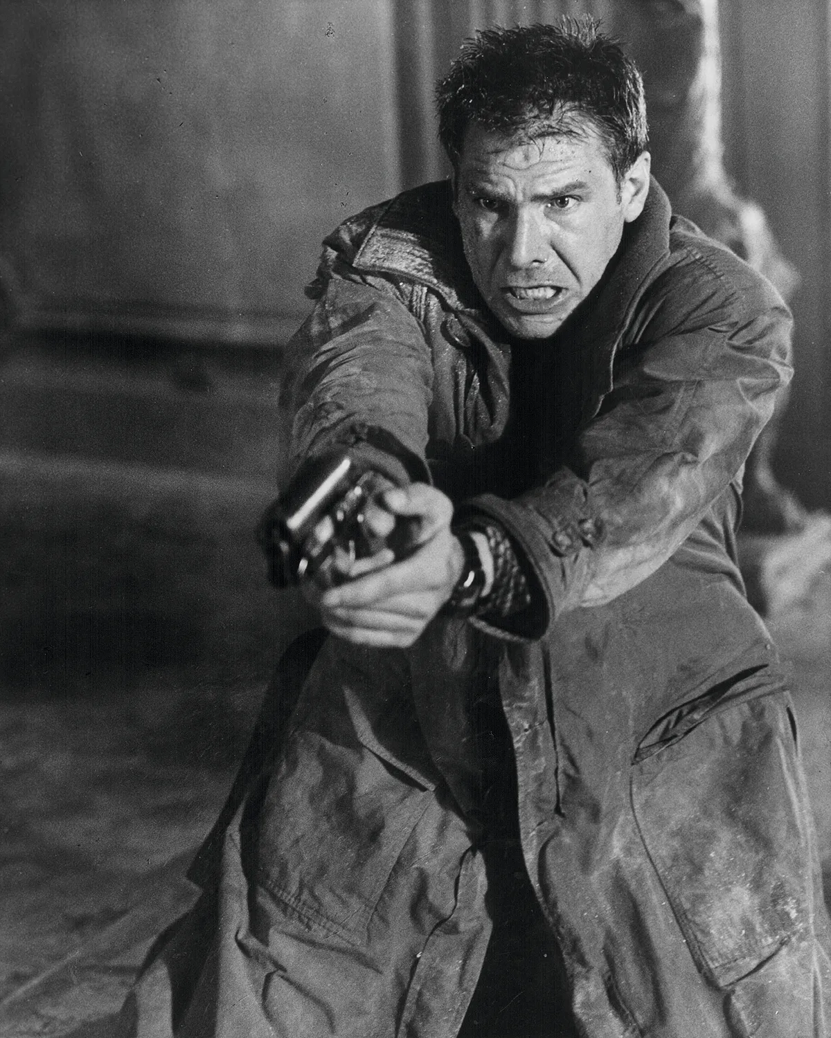 Actor Harrison Ford holding a gun, in a scene from the movie 'Blade Runner', 1982. (Photo by Stanley Bielecki Movie Collection/Getty Images)