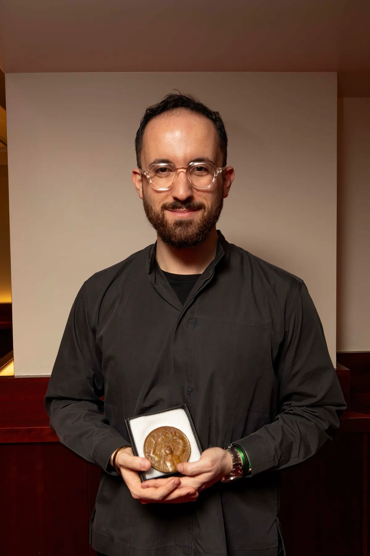A portrait of pianist Igor Levit holding the Wigmore Hall Medal