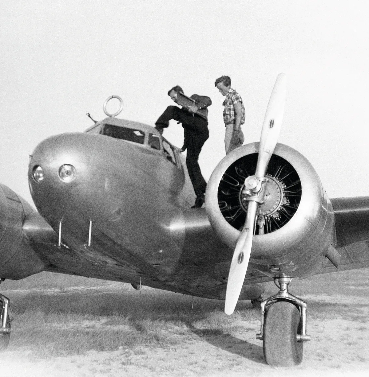 A black and white image of Amelia Earhart and her navigator Fred Noonan boarding a plane