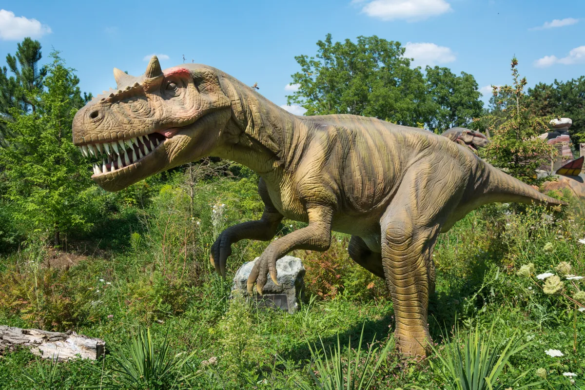 A tyrannosaurus rex standing in a field