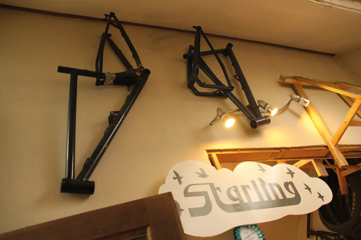 mountain bike frames hanging on the wall in Starling Cycles workshop