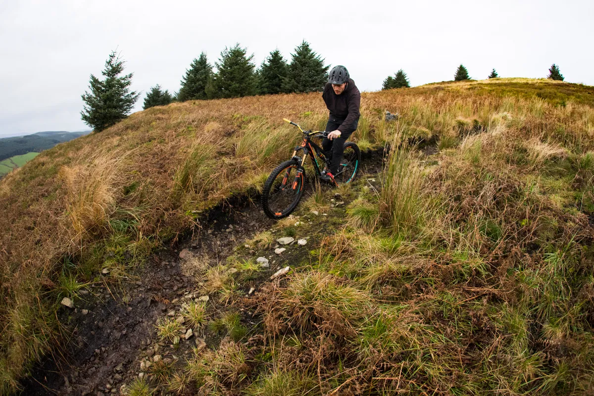 Tommy Wilkinson rides one-handed at Ae forest on a Scott Genius bike