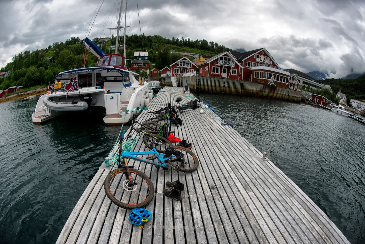 Bikes lying on the jetty next to a yacht in Norway