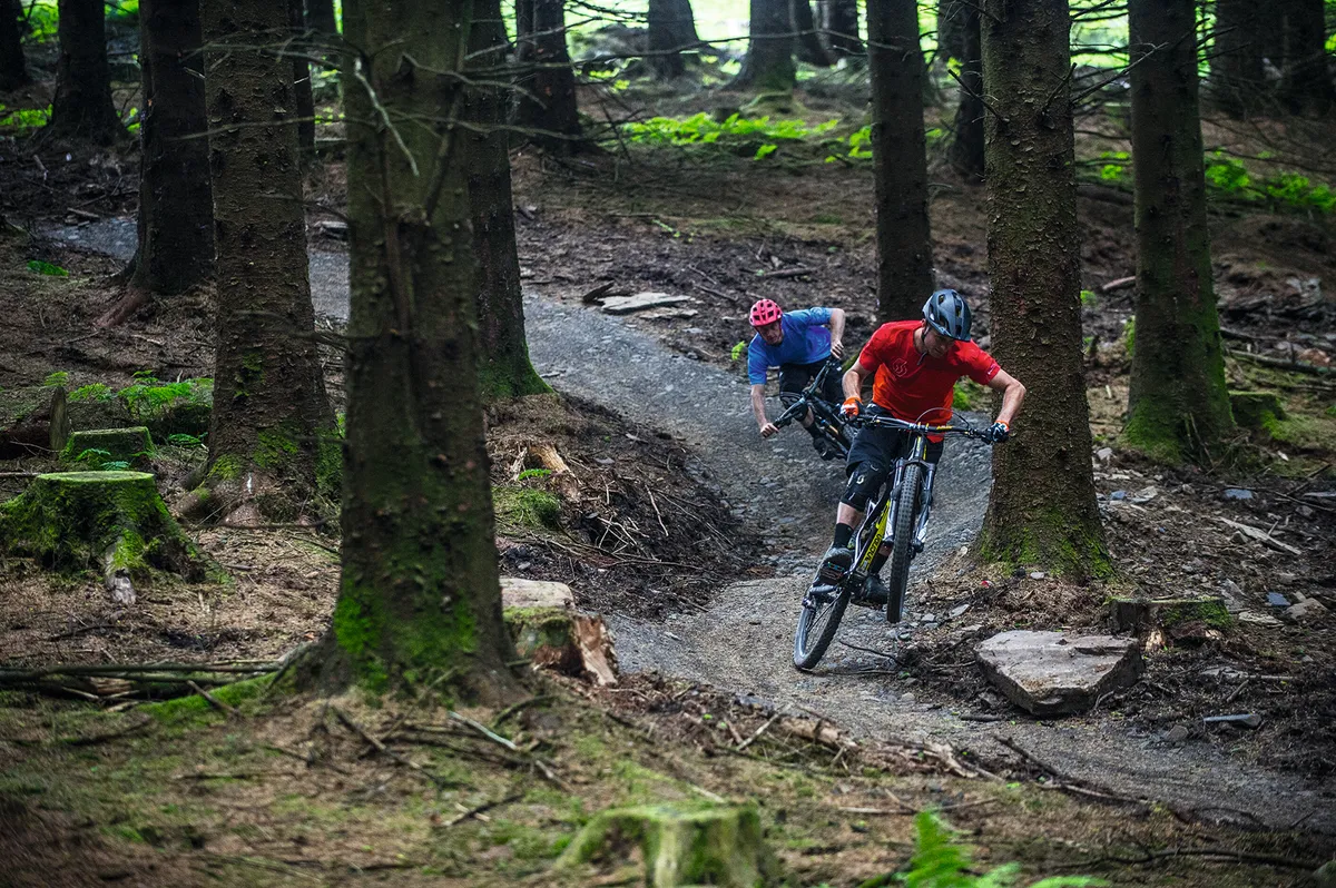 Two riders flowing down trail centre trails
