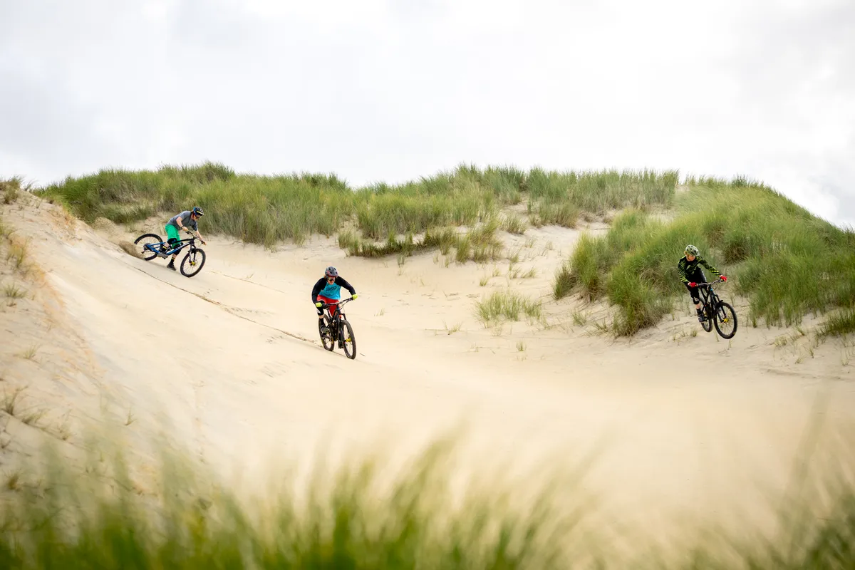 The Dudes of Hazard riding down a sand dune